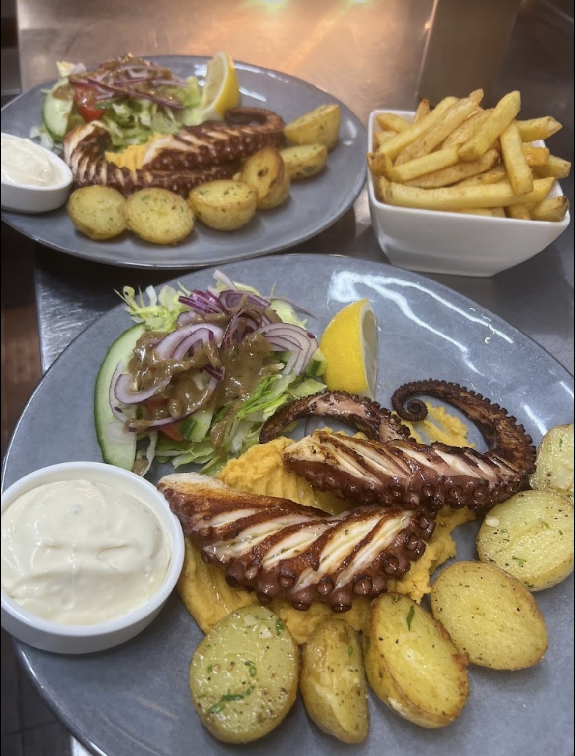 Grilled octopus with potatoes and salad
